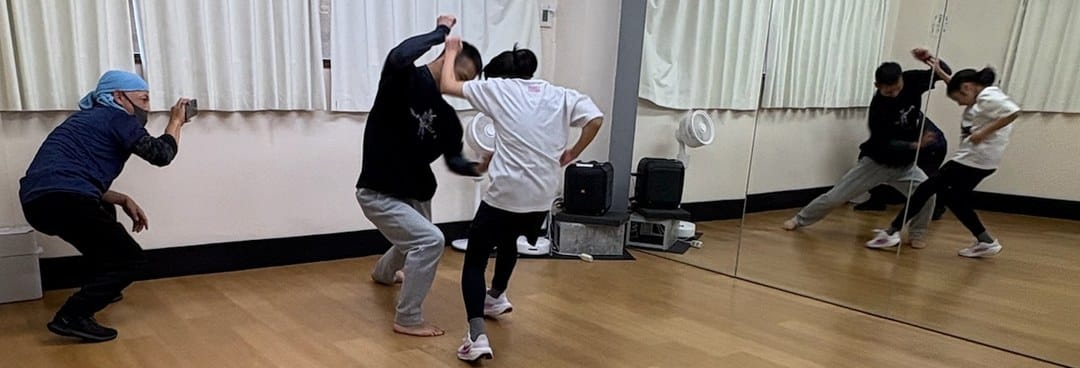 2人で組んだ短いアクションシーンを、講師がスマートフォンで撮影している様子